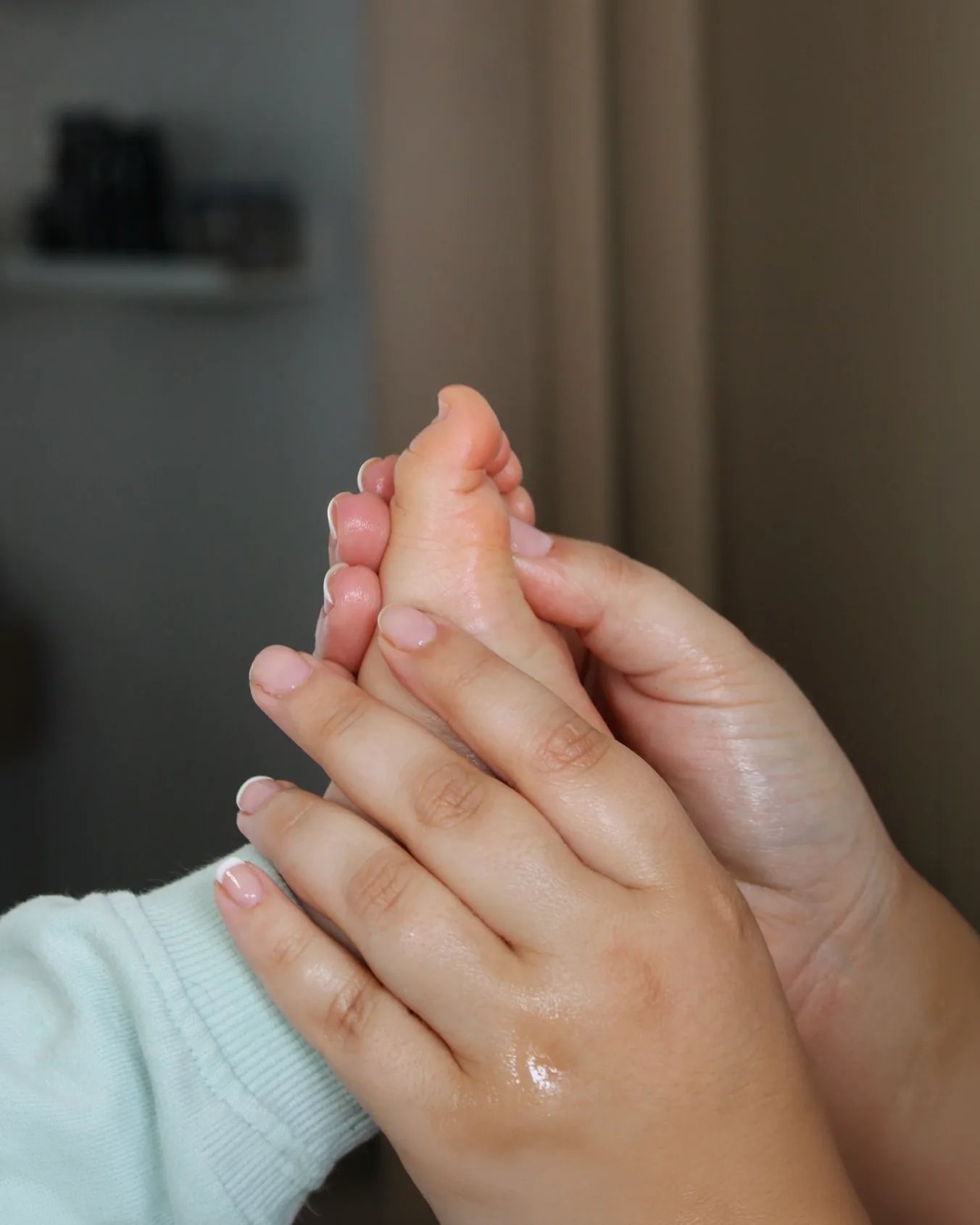 Gros plan d'un soin de réflexologie : les mains de Carla enveloppant le pied d'un enfant